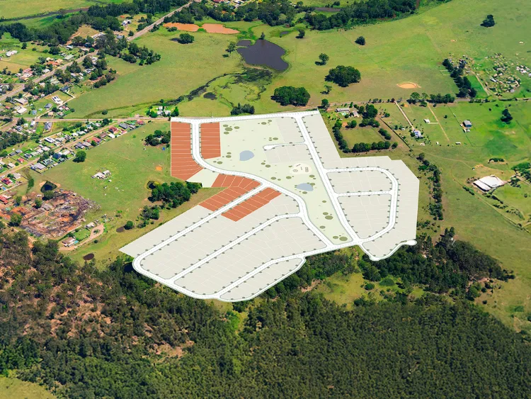 Aerial view of Millfield Rise Estate showing a large commercial or industrial development with red-roofed buildings and extensive paved parking areas surrounded by green fields, scattered trees, and residential properties in a rural landscape.